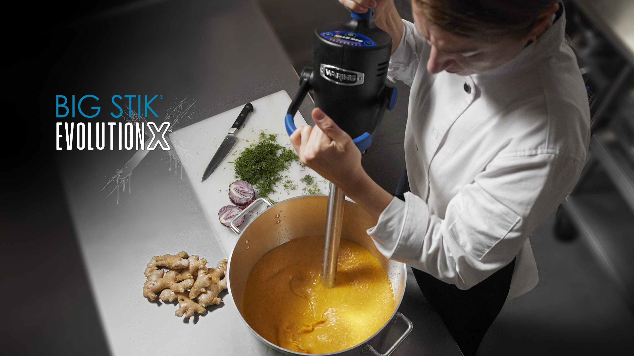 Chef using immersion blender in stock pot