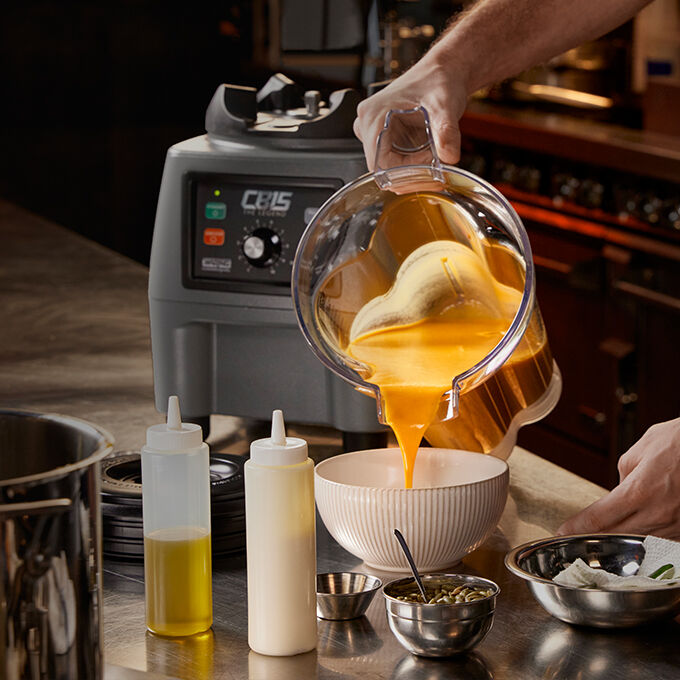 CB15VP blender base on counter with chef pouring butternut squash soup from the copolyester jar