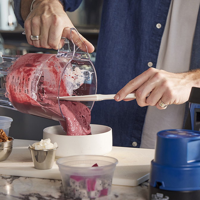Hands emptying Ellipse blender into bowl