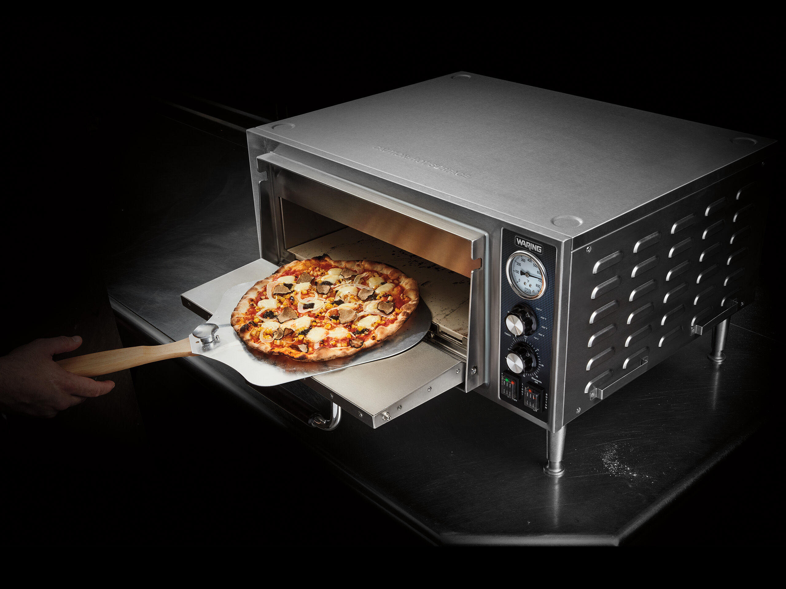 Pizza on paddle going into pizza oven | Waring