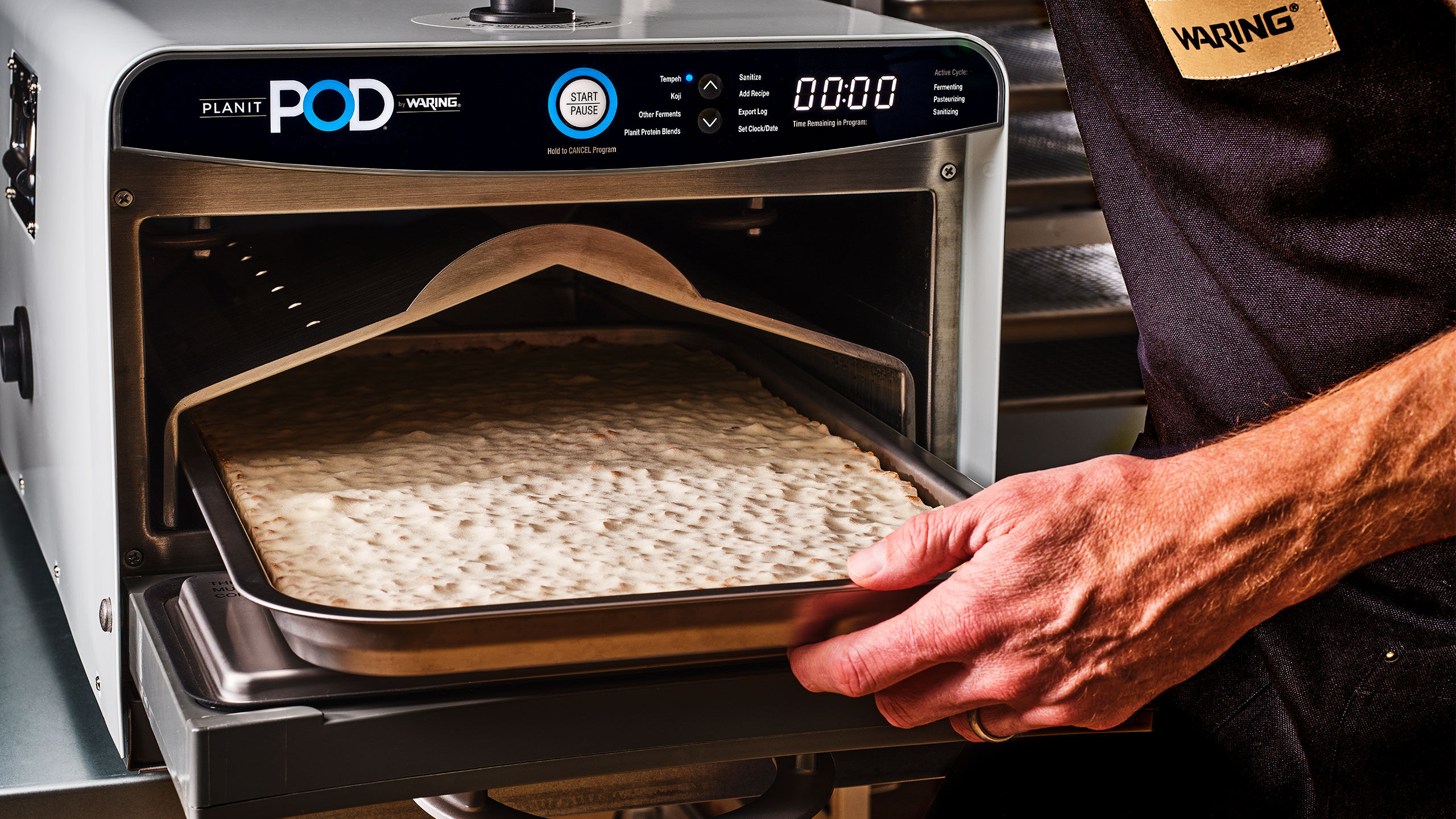 Planit POD Fermentation Chamber by waring on wooden counter with bowl of hummus in front of it