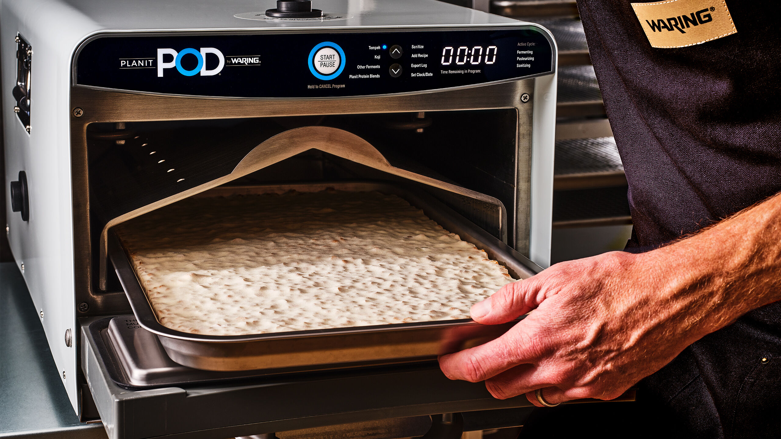 hand pulling a tray out of the planit pod fermenation chamber
