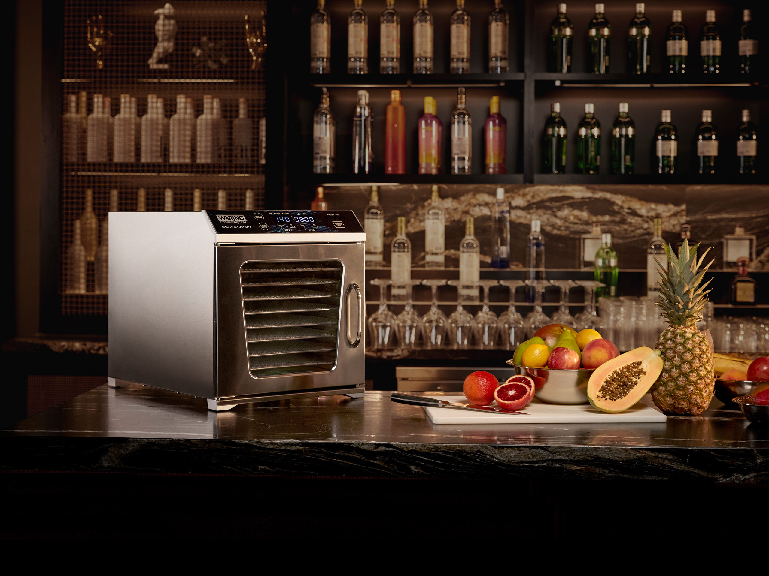 Food dehydrator on bar next to fruits | Waring
